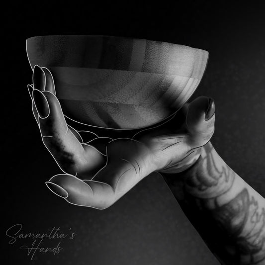 Tattooed hand holding a wooden bowl, black and white artistic photo