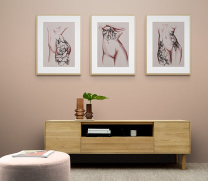 Modern living room cabinet with glass vases, green plant, and framed tattoo art prints above.