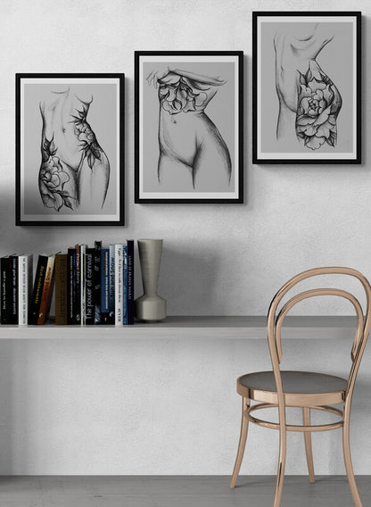 Minimalist wall-mounted desk with books, light metal chair, and framed floral tattoo art prints
