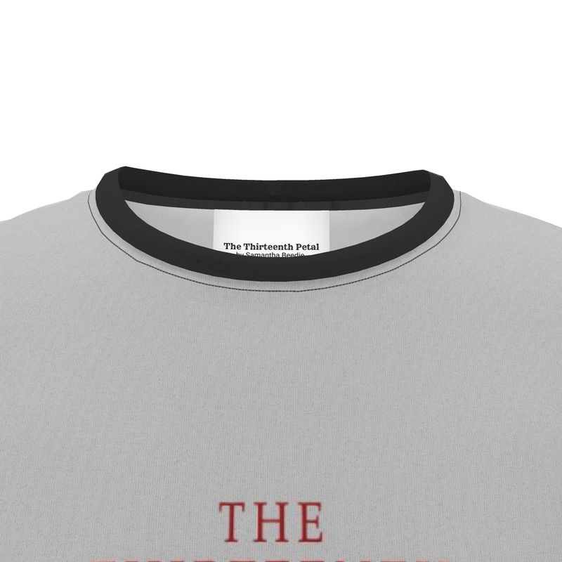 The close up of a black collar on a grey shirt with the brand name The Thirteenth Petal on it
